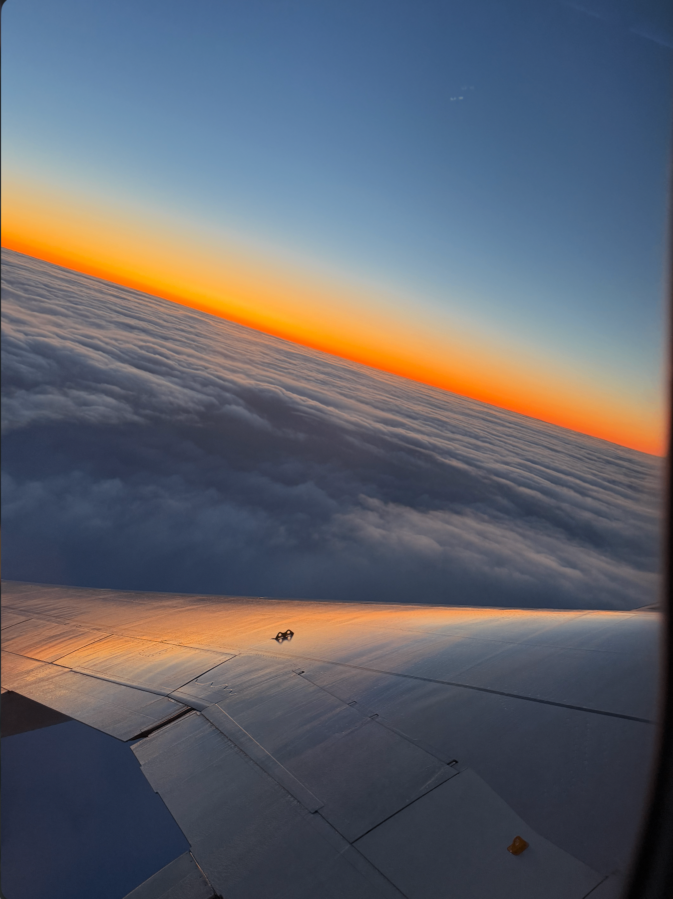 Sunset above the clouds from a plane window